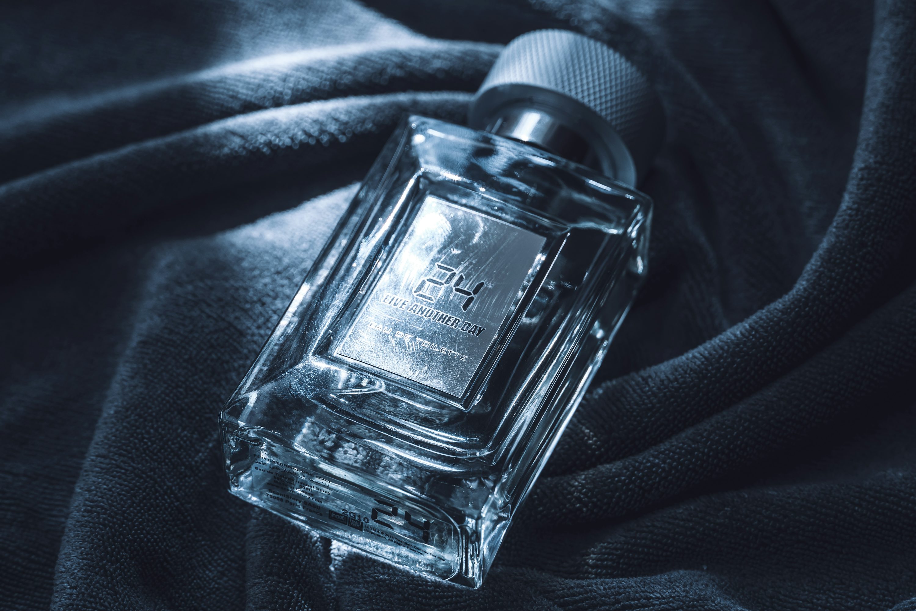 Illustrative glass fragrance bottle on dark fabric